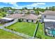 Aerial view of backyard featuring lush green lawn and white picket fence, surrounded by well-maintained houses at 12838 Wildflower Meadow Dr, Riverview, FL 33579