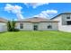 Home backyard featuring green grass, a sliding glass door, and privacy fence at 12838 Wildflower Meadow Dr, Riverview, FL 33579