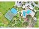 Aerial view of tennis courts, basketball court, and swimming pool surrounded by lush landscaping and trees at 12838 Wildflower Meadow Dr, Riverview, FL 33579
