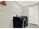 A laundry room with black washer and dryer machines and a metal shelf at 12838 Wildflower Meadow Dr, Riverview, FL 33579