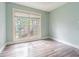 Comfortable bedroom with wood-look flooring and a large window at 13702 Sweetwater Cove Pl # 25, Tampa, FL 33613