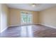 Light-filled bedroom with wood-look flooring and a large window at 13702 Sweetwater Cove Pl # 25, Tampa, FL 33613