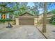 The tan garage features a brown wood door and driveway with basketball hoop at 13702 Sweetwater Cove Pl # 25, Tampa, FL 33613
