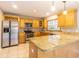 A well-equipped kitchen with wooden cabinets, granite countertops, and stainless steel appliances at 13702 Sweetwater Cove Pl # 25, Tampa, FL 33613