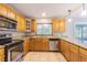 Bright kitchen with wooden cabinetry, granite countertops, and stainless steel appliances at 13702 Sweetwater Cove Pl # 25, Tampa, FL 33613