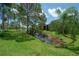 Scenic backyard showcasing a lush green lawn and a tranquil pond surrounded by trees at 13851 Lake Point Dr, Clearwater, FL 33762