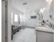 Bright bathroom features white tile, glass shower, double vanity with granite counters, and gray chaise lounge at 13851 Lake Point Dr, Clearwater, FL 33762