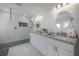 This bathroom features white cabinets, dual sinks, a glass shower, and a modern lighting fixture at 13851 Lake Point Dr, Clearwater, FL 33762