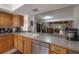 Kitchen showcasing oak cabinets, and stainless steel dishwasher, with views to the staircase at 13851 Lake Point Dr, Clearwater, FL 33762