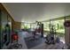 Spacious enclosed lanai with gym equipment and a dining set overlooks lush greenery at 13851 Lake Point Dr, Clearwater, FL 33762