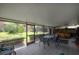 Enclosed lanai featuring a dining set, exercise equipment, and views of the lush backyard at 13851 Lake Point Dr, Clearwater, FL 33762