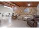 Spacious living room features a stone wall, wood ceiling, and lots of natural light at 13851 Lake Point Dr, Clearwater, FL 33762