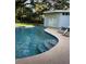 Backyard pool featuring a concrete patio, a covered area, and mature landscaping at 14803 Tulip Dr, Tampa, FL 33613