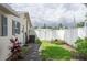 Fully fenced in backyard with lush grass, an AC unit, and a gate to the side yard at 1806 11Th Sw St, Largo, FL 33778