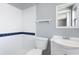 A white and blue tiled bathroom featuring a vanity, toilet, and tiled shower at 1806 11Th Sw St, Largo, FL 33778