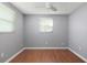 Bedroom with wood flooring, two windows, ceiling fan, and neutral gray walls at 1806 11Th Sw St, Largo, FL 33778