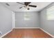 This bedroom is painted gray, with wood flooring, and a ceiling fan at 1806 11Th Sw St, Largo, FL 33778