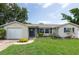 Well-maintained home with a front yard featuring shrubs and mulch-filled garden beds at 1806 11Th Sw St, Largo, FL 33778