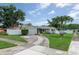 Charming single-story home with a well-manicured lawn, circular driveway, and white picket fence at 1806 11Th Sw St, Largo, FL 33778