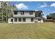 Expansive backyard featuring lush lawn and view of the two-story home, creating a serene and private outdoor space at 19003 Cedar Ln, Lutz, FL 33548
