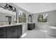 Elegant bathroom with marble accents, dual vanities, a soaking tub, and ample natural light at 19003 Cedar Ln, Lutz, FL 33548