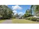 Stunning exterior of a two-story home with a spacious front yard and mature trees, offering curb appeal and privacy at 19003 Cedar Ln, Lutz, FL 33548