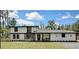 Charming two-story home with white facade, black trim, and a well-manicured lawn at 19003 Cedar Ln, Lutz, FL 33548