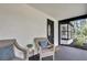 Covered front porch with two chairs and a view of the front yard at 19003 Cedar Ln, Lutz, FL 33548