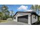 Two-car garage with black doors and white trim, plus bonus storage shed at 19003 Cedar Ln, Lutz, FL 33548