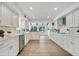 Well-lit kitchen featuring white cabinetry, modern appliances, and a view of the backyard at 19003 Cedar Ln, Lutz, FL 33548