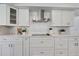 Modern kitchen features white cabinetry, stone countertops, and stainless steel range hood at 19003 Cedar Ln, Lutz, FL 33548