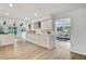 Bright and open kitchen featuring white cabinets, stainless steel appliances, and seamless flow into the adjacent living area at 19003 Cedar Ln, Lutz, FL 33548