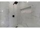 Sleek shower with white marble-look tile, a rainfall showerhead, and built-in niche at 19003 Cedar Ln, Lutz, FL 33548