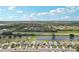 Aerial view of the homes in a community, with a pond, and mature trees on a partly cloudy day at 1901 E Del Webb Blvd, Sun City Center, FL 33573
