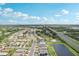 Aerial view showing community layout with houses, roadways, pond, highway access, and trees at 1901 E Del Webb Blvd, Sun City Center, FL 33573