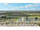 Aerial view of the homes in a community, with a pond and pin-drop for location, on a partly cloudy day at 1901 E Del Webb Blvd, Sun City Center, FL 33573