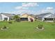 Well-maintained back yard with a spacious lawn, mature landscaping, and a screened lanai at 1901 E Del Webb Blvd, Sun City Center, FL 33573