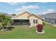 Well-maintained backyard featuring lush grass, a screened lanai, and manicured landscaping at 1901 E Del Webb Blvd, Sun City Center, FL 33573