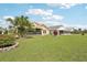 Lush backyard with a screened-in lanai, palm trees and beautiful landscaping at 1901 E Del Webb Blvd, Sun City Center, FL 33573