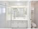 Bathroom with white vanity, large mirror, enclosed shower, and toilet at 1901 E Del Webb Blvd, Sun City Center, FL 33573
