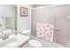 Bright bathroom featuring a shower with flamingo-themed curtain, white fixtures and complementary decor at 1901 E Del Webb Blvd, Sun City Center, FL 33573