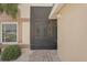 View of the front door with a security gate leading to a brick paver walkway and landscaped garden at 1901 E Del Webb Blvd, Sun City Center, FL 33573