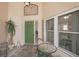 Covered front entrance features a glass top table with seating area, and green door at 1901 E Del Webb Blvd, Sun City Center, FL 33573