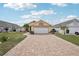 Charming home with a well-maintained lawn, brick driveway, and two-car garage, perfect for Gathering living at 1901 E Del Webb Blvd, Sun City Center, FL 33573