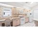 Bright kitchen featuring neutral-toned cabinetry, white appliances, and floral wallpaper at 1901 E Del Webb Blvd, Sun City Center, FL 33573