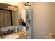 Bathroom featuring granite countertops, a mirrored cabinet, and a storage shelf at 2101 Sunset Point Rd # 2304, Clearwater, FL 33765