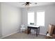 Bright bedroom with neutral carpet, fan, two windows, and a desk at 2101 Sunset Point Rd # 2304, Clearwater, FL 33765