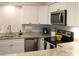 Well-lit kitchen featuring white cabinets, stainless steel appliances, and sleek countertops at 2101 Sunset Point Rd # 2304, Clearwater, FL 33765