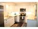 Modern kitchen featuring white cabinets, stainless steel appliances, and granite countertops at 2101 Sunset Point Rd # 2304, Clearwater, FL 33765