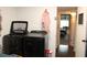 Laundry room with dark washer and dryer leading to bedroom at 2101 Sunset Point Rd # 2304, Clearwater, FL 33765